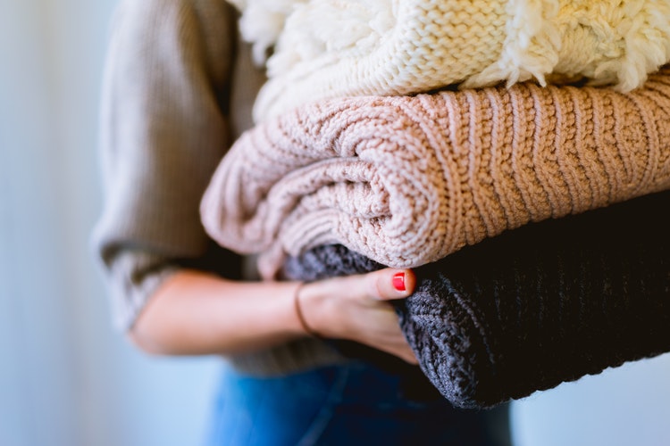 syksyn valokuvaideoita instagramille - tyttö kädessään taitettu villapaita